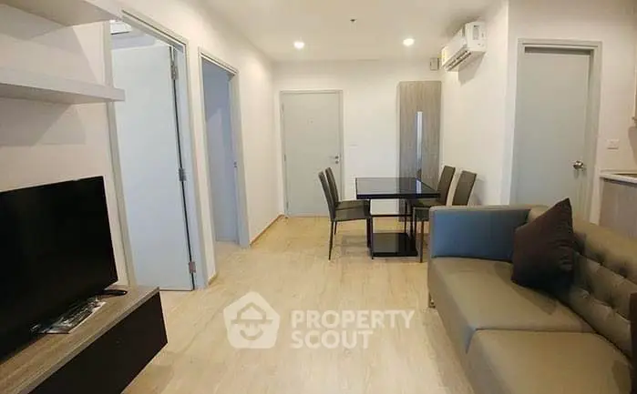 Modern living room with dining area and sleek furniture in a cozy apartment.