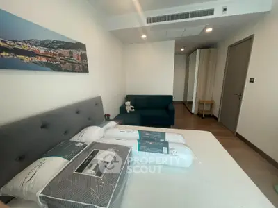 Modern bedroom with cozy sofa and stylish decor in a spacious apartment.