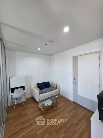 Cozy living room with modern decor and wooden flooring in a stylish apartment.