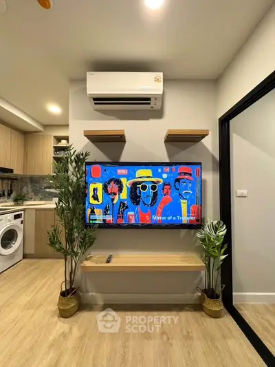 Modern living room with stylish decor and wall-mounted TV in a cozy apartment.