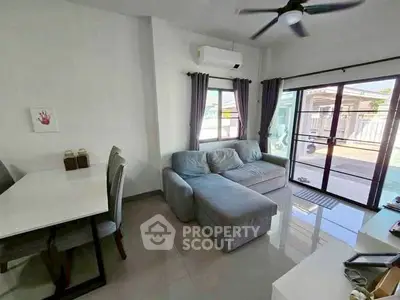 Modern living room with cozy sofa and large windows for natural light.