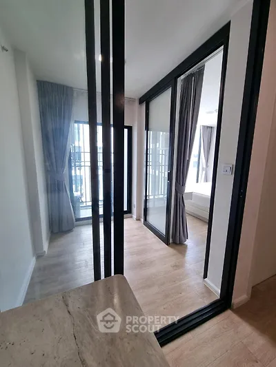 Modern apartment interior with sliding glass doors and wooden flooring, featuring a bright and airy ambiance.