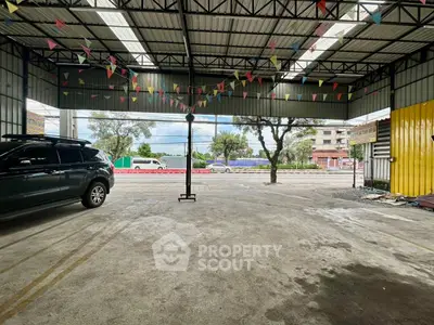 Spacious covered parking area with festive bunting and street view
