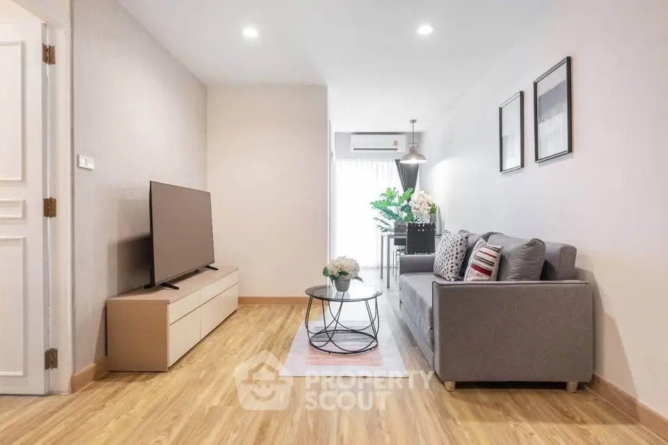 Modern living room with sleek design, featuring a cozy sofa, flat-screen TV, and elegant decor.