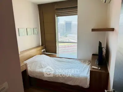 Cozy bedroom with modern furnishings and city view, perfect for urban living.