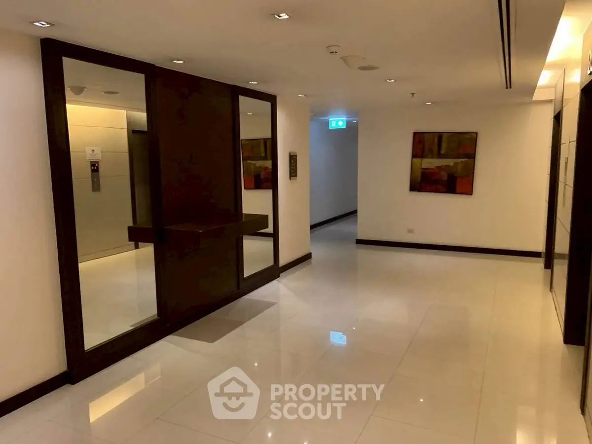 Elegant building corridor with polished floors and modern elevator access.