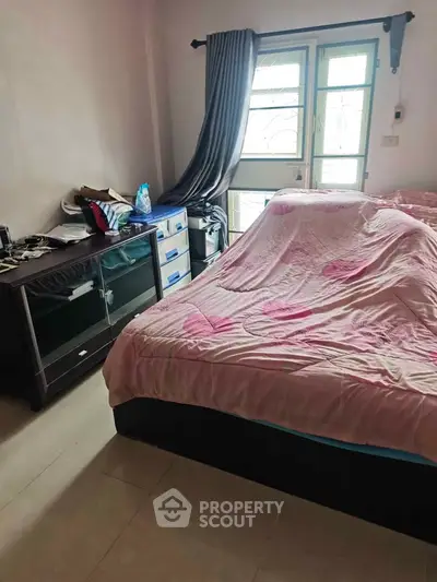 Cozy bedroom with natural light and modern furnishings, perfect for relaxation and comfort.