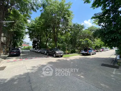 Spacious residential street with ample parking and lush greenery