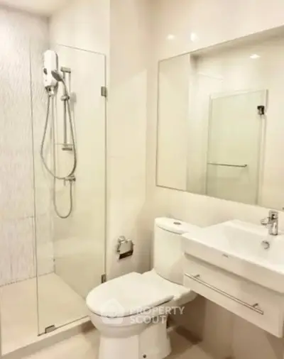 Modern bathroom with glass shower and sleek fixtures in a contemporary apartment.