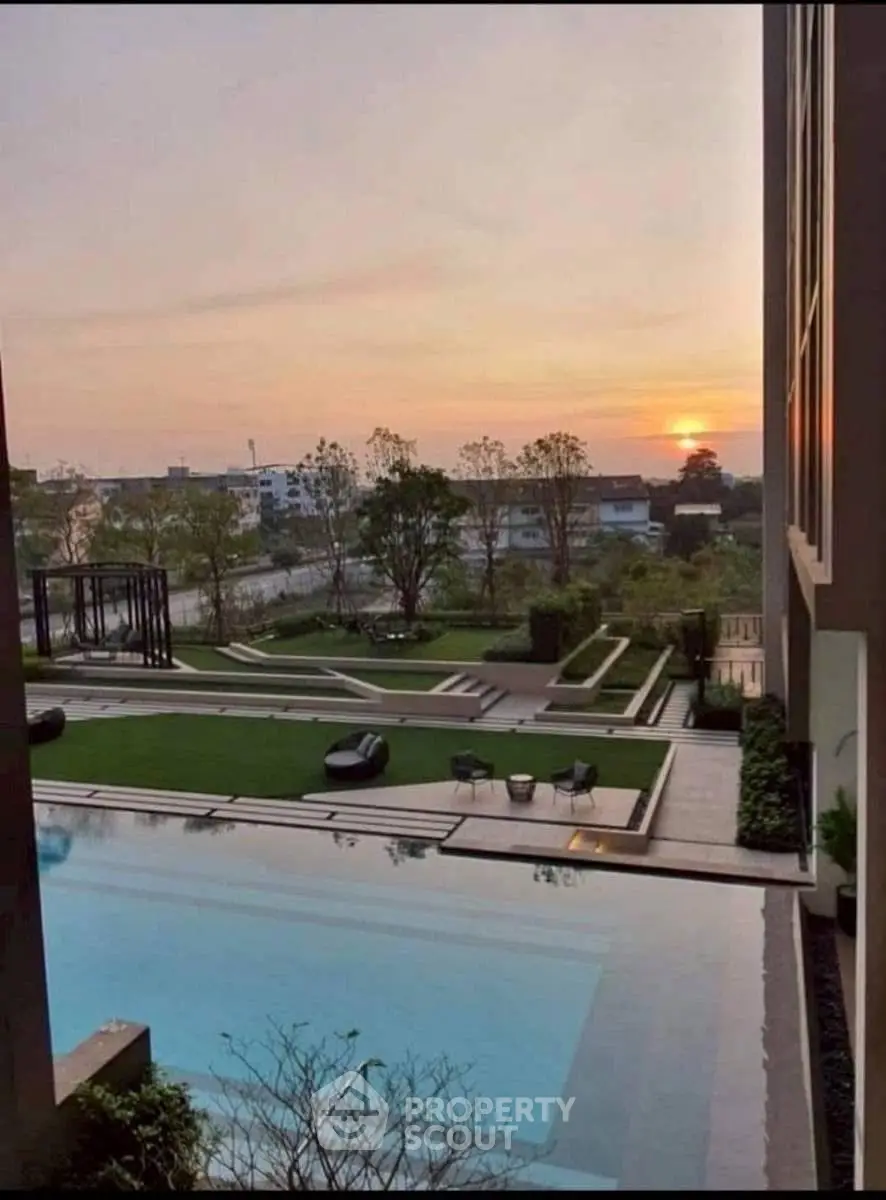 Luxurious apartment pool area with stunning sunset view and modern landscaping.