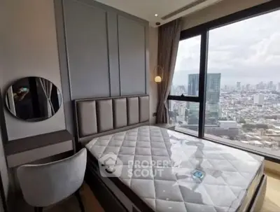 Modern bedroom with city view, featuring stylish decor and large window for natural light.