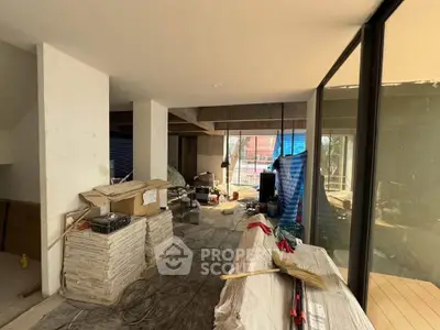 Spacious under-construction interior with large windows and modern design potential.