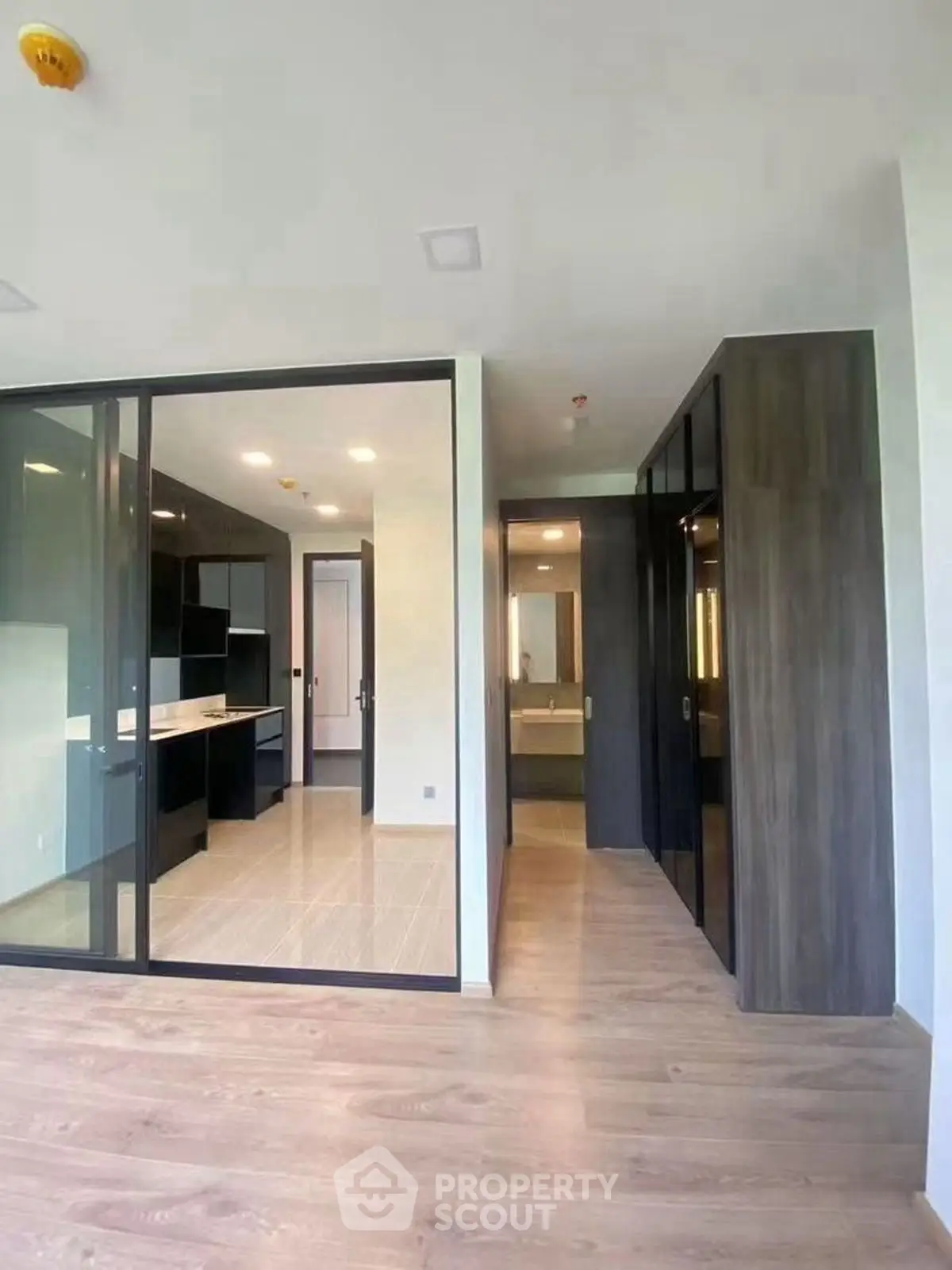 Modern open layout with sleek kitchen and glass partitions in a stylish apartment.