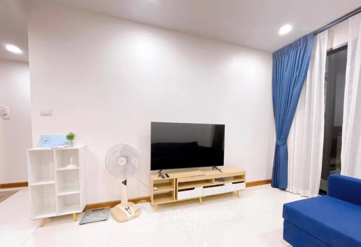 Modern living room with sleek TV stand, blue curtains, and minimalist decor.