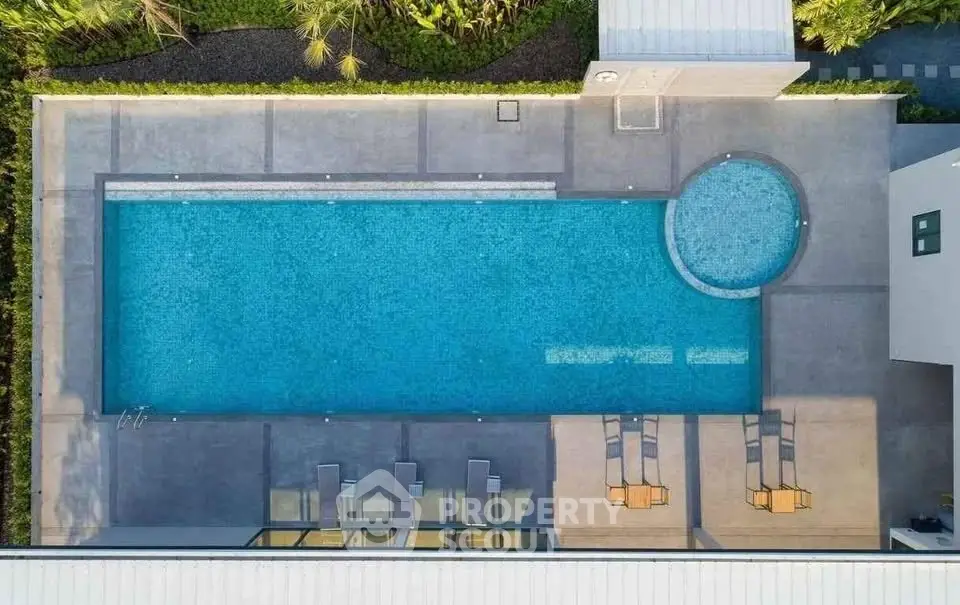 Stunning aerial view of modern pool with sun loungers in luxury property