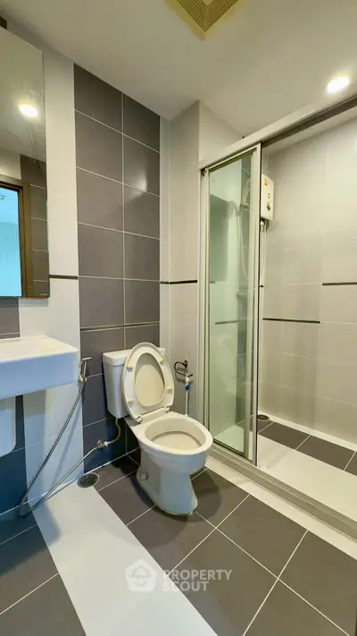 Modern bathroom with sleek design featuring a shower enclosure and stylish tiles.