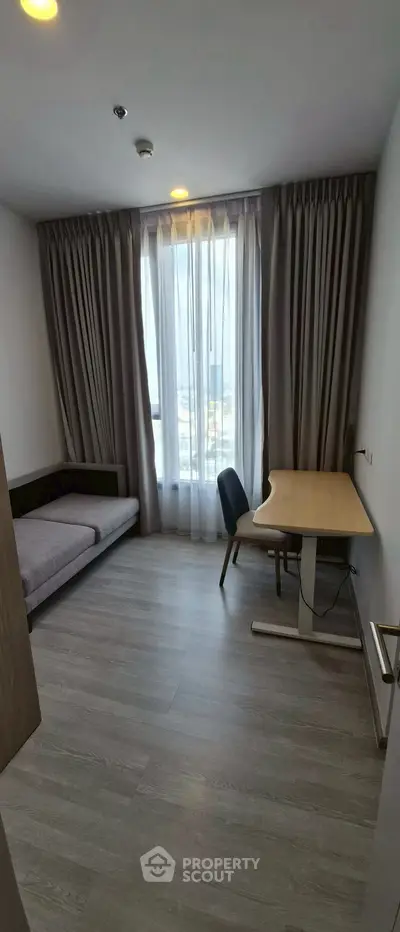 Modern study room with desk and sofa bed, large window with city view