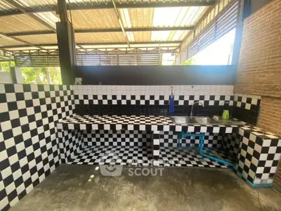 Stylish open kitchen with black and white checkered tiles and modern fixtures