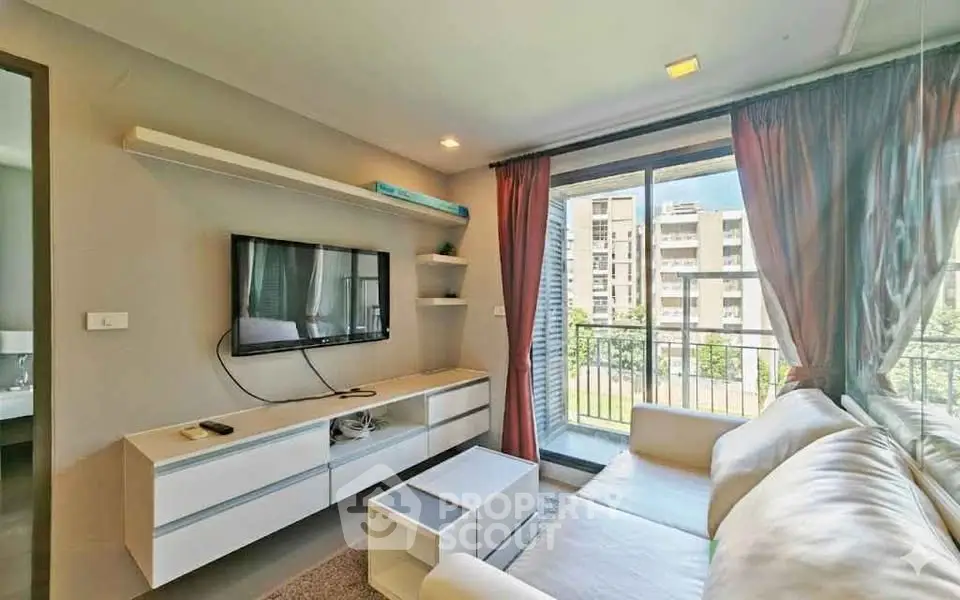 Modern living room with large window and stylish furniture in a bright apartment.