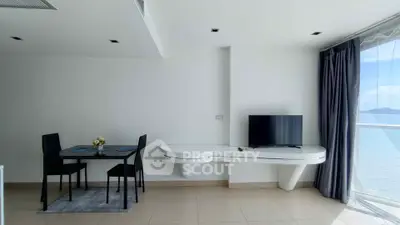 Modern living room with ocean view, sleek furniture, and natural light