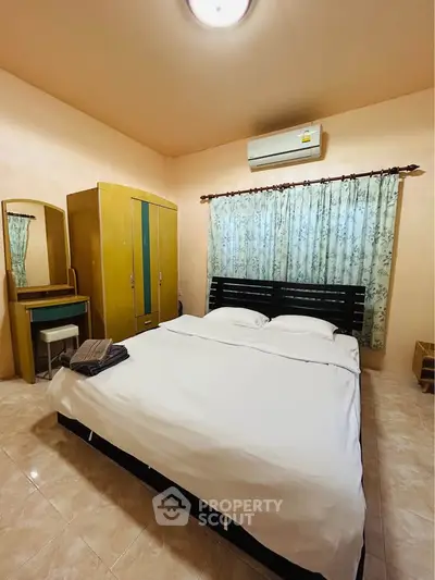 Cozy bedroom with air conditioning, wardrobe, and elegant curtains, perfect for restful nights.