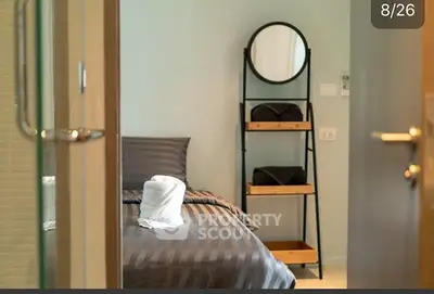Cozy bedroom with modern decor and stylish shelving unit.