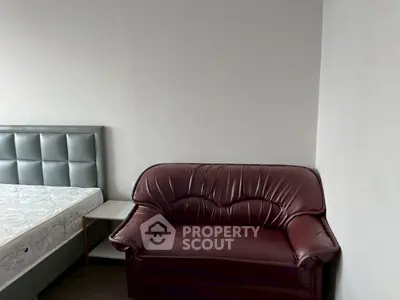 Cozy bedroom with leather sofa and modern bed frame