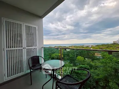 Stunning balcony with breathtaking view of lush greenery and distant ocean horizon.