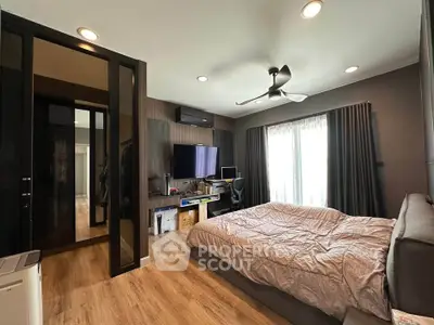 Modern bedroom with sleek design, featuring a large bed, stylish ceiling fan, and ample natural light.