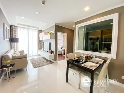 Elegantly furnished open-plan living space with glossy tiled floors, modern dining set, and a cozy lounge area leading to a bright bedroom.