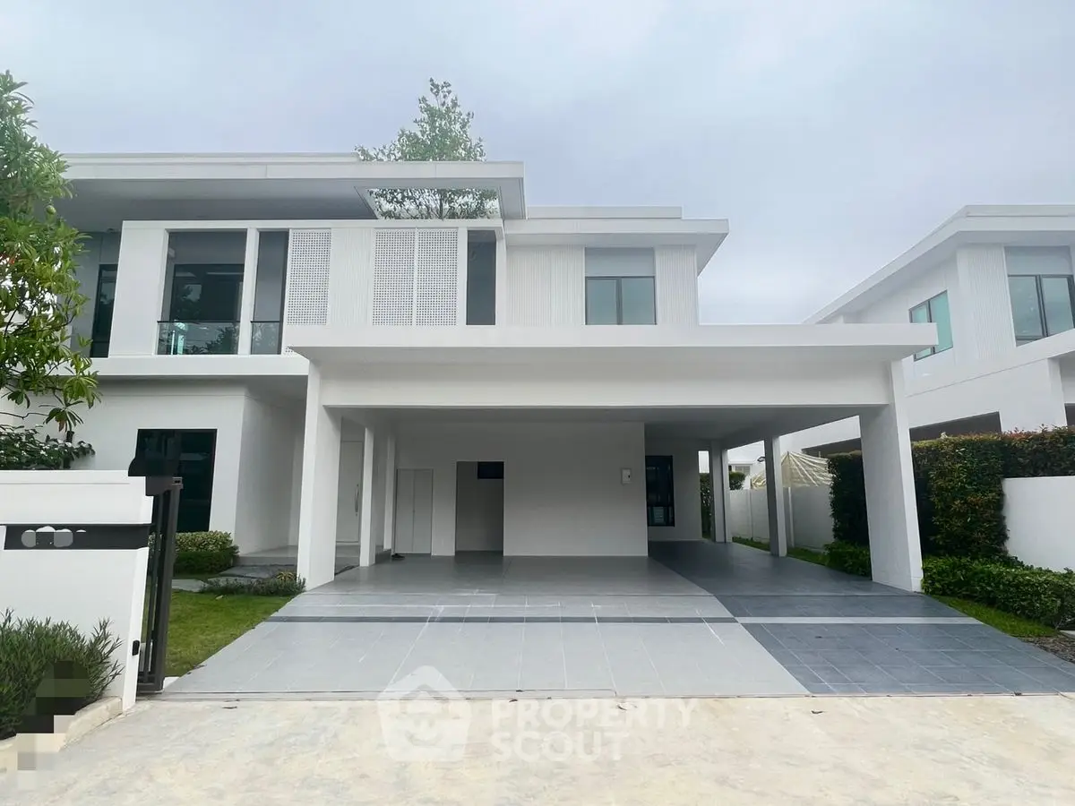 Modern two-story house with spacious driveway and sleek architectural design.