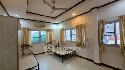 Spacious bedroom with twin beds and natural light in modern apartment.