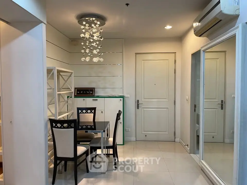 Stylish dining area with modern chandelier and sleek furniture in a contemporary apartment.