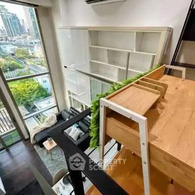 Modern loft apartment with high ceilings and large windows offering city views.