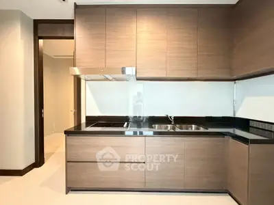 Modern kitchen with sleek wooden cabinetry and black countertops