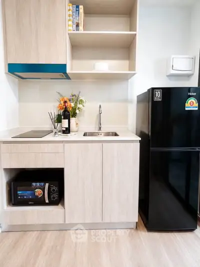 Modern kitchen with sleek appliances and stylish cabinetry in a contemporary apartment.