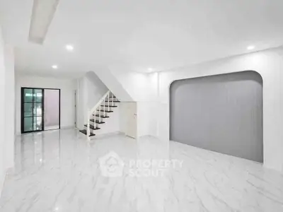 Spacious modern living room with sleek staircase and elegant marble flooring