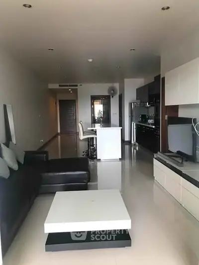 Modern open-plan living room with sleek kitchen and stylish furniture in a contemporary apartment.