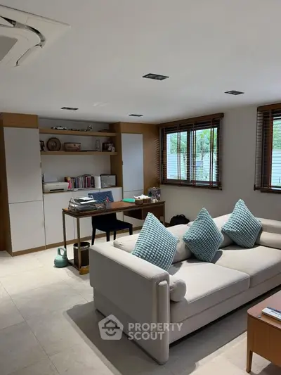 Spacious living room with modern decor and large windows offering natural light
