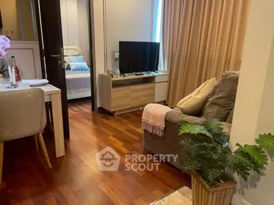 Cozy living room with wooden flooring and modern decor adjacent to a stylish dining area.