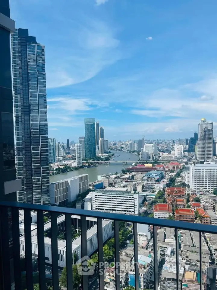Stunning cityscape view from high-rise balcony overlooking river and skyline.