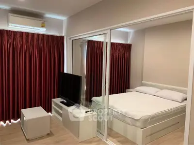 Modern studio apartment with glass partition, red curtains, and sleek furnishings.