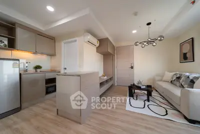 Modern living room with open kitchen, stylish decor, and cozy ambiance.