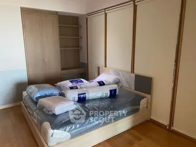 Spacious bedroom with wooden flooring and modern bed setup