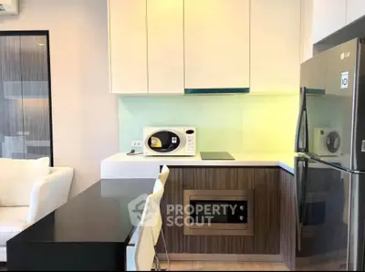 Modern kitchen with sleek appliances and stylish cabinetry in a contemporary apartment.