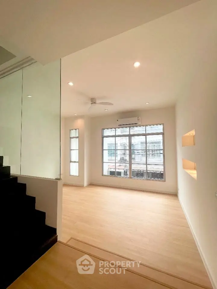 Spacious modern living room with large windows and wooden flooring