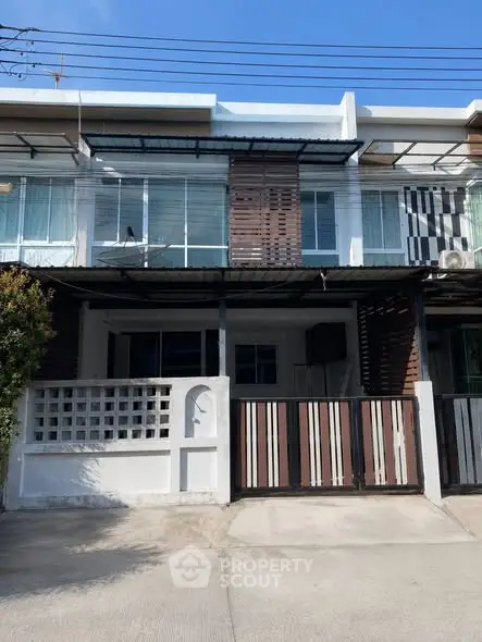 Modern townhouse exterior with gated entrance and large windows, perfect for urban living.