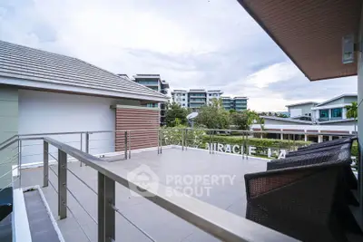 Spacious balcony with modern railing and scenic view of residential area.