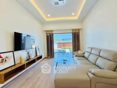 Modern living room with sleek furniture and pool view, featuring a cozy sofa and wall-mounted TV.