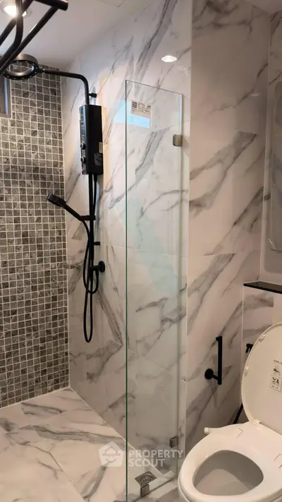 Modern bathroom with marble tiles and glass shower enclosure